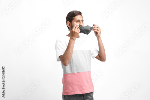 Young asian man wearing medical mask on white background. Coronavirus or covid-19 protection concept. © Niks Ads