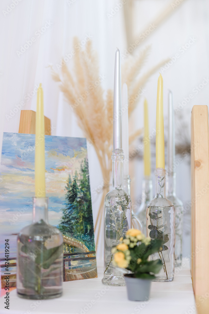yellow and white candles with flowers and bottles