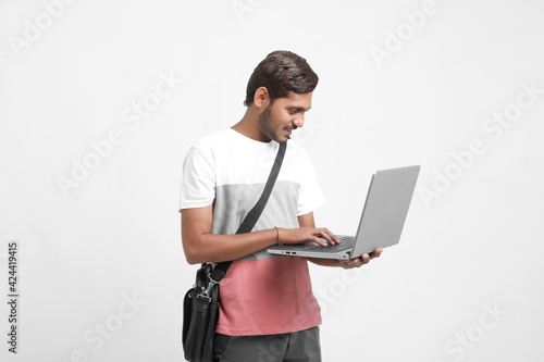 Indian college student using laptop on white background.