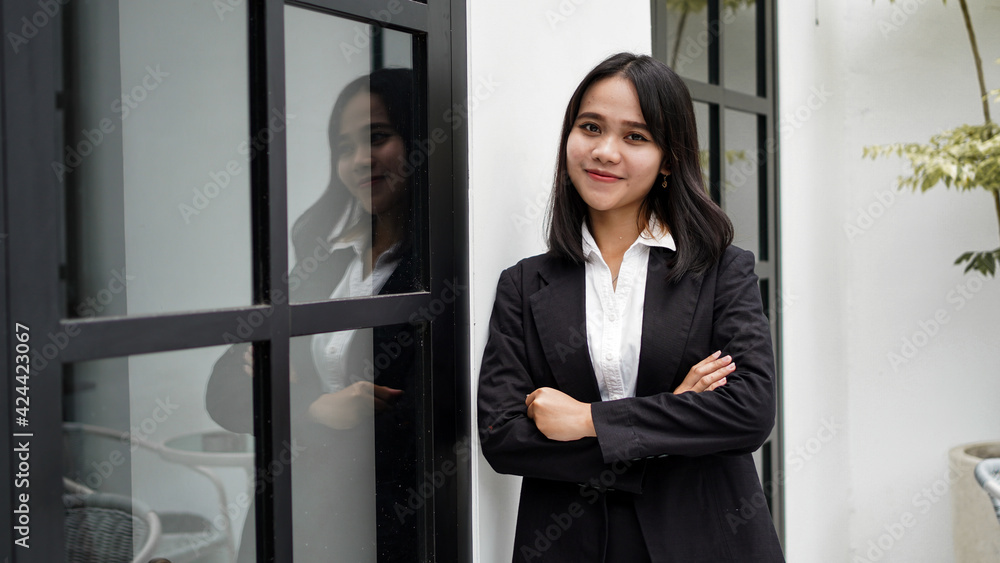 Asian business woman smiling and standing in front office Asian business woman smiling and standing in front office