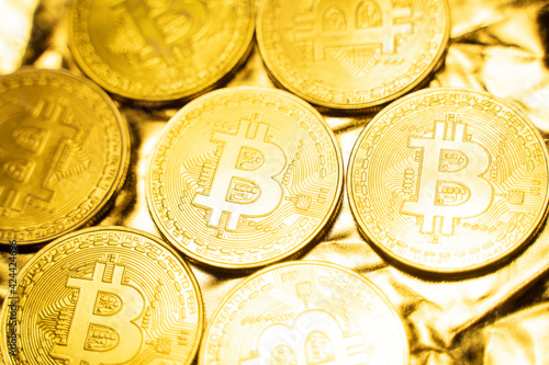 Golden bitcoin Coins on a golden background. Trading on the cryptocurrency exchange. Cryptocurrency Stock Market Concept. Virtual money concept. Mining or blockchain technology. Business concept.