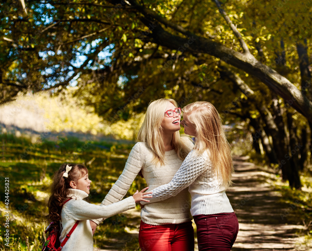 Fototapeta premium Three happy sisters playing in autumn forest on sunny warm day