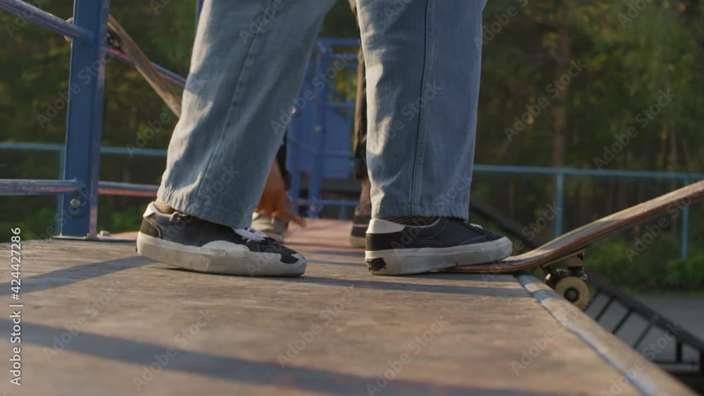 Close up shot of unrecognizable teenager standing up and skating down ramp Close up shot of unrecognizable teenager standing up and skating down ramp
