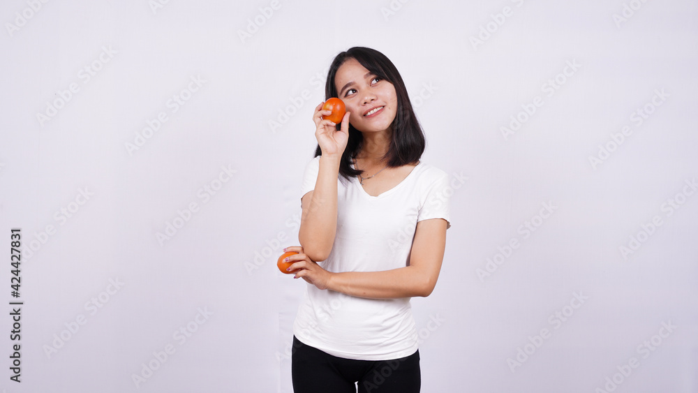 beautiful asian women thinking with a tomato isolated on white background beautiful asian women thinking with a tomato isolated on white background