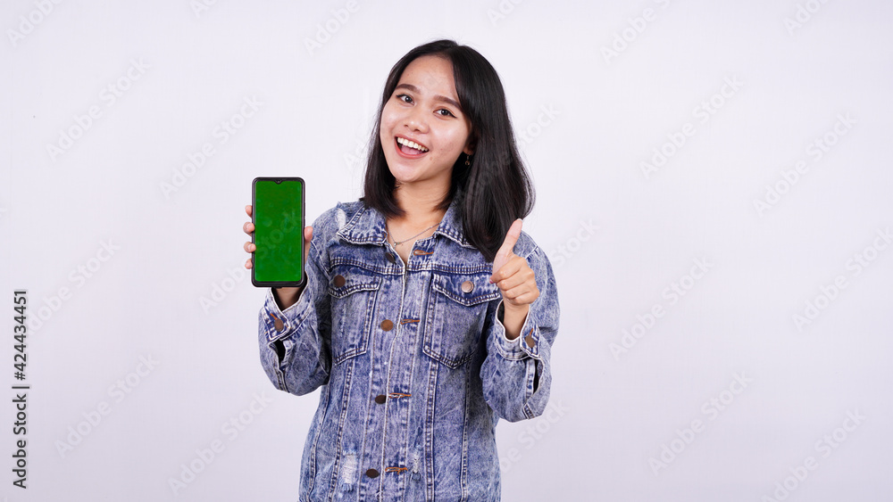 Asian women smiling wearing jeans jacket and holding green screen phone with isolated white background Asian women smiling wearing jeans jacket and holding green screen phone with isolated white background