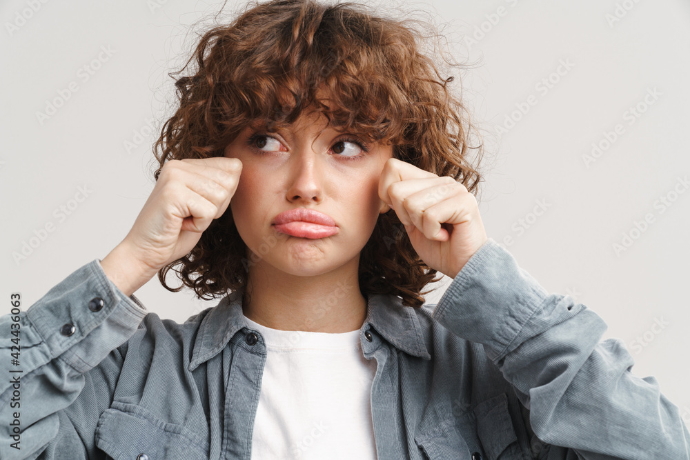 Unhappy ginger woman in shirt crying and looking aside