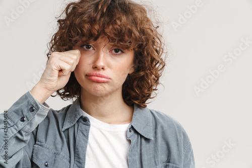 Unhappy ginger woman in shirt crying and looking at camera