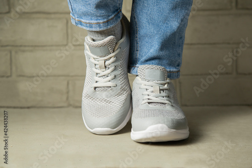 Modern young woman in stylish jeans in fashionable youth sneakers