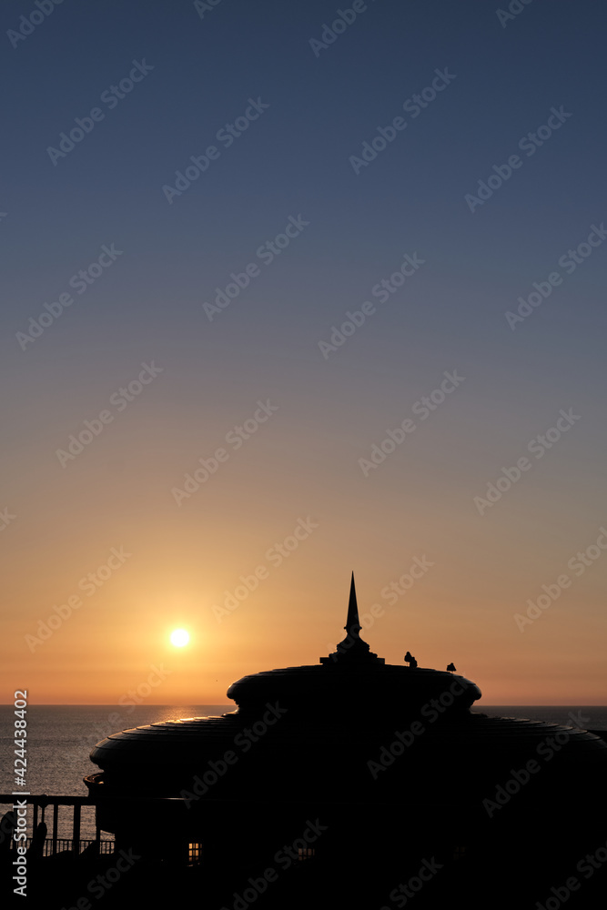 Golden Sunrise with clear skies and a silhouette of the bandstand dome in Eastbourne, East Sussex
