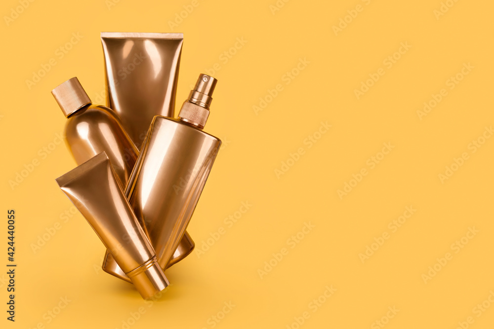 Golden bottles, cosmetic products on yellow background. Luxury beauty style. Gold cosmetic containers. Mockup bottles, cosmetics branding, hair or body care concept. Copy space, empty place for text.