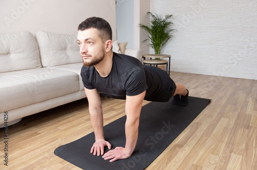 sport, fitness and healthy lifestyle concept - man doing plank exercise at home. workout abs, stability body, man training tricep pushups.