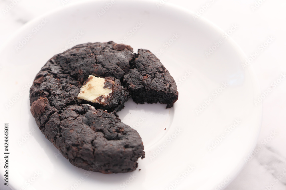 half eaten chocolate sweet cookies on plate half eaten chocolate sweet cookies on plate