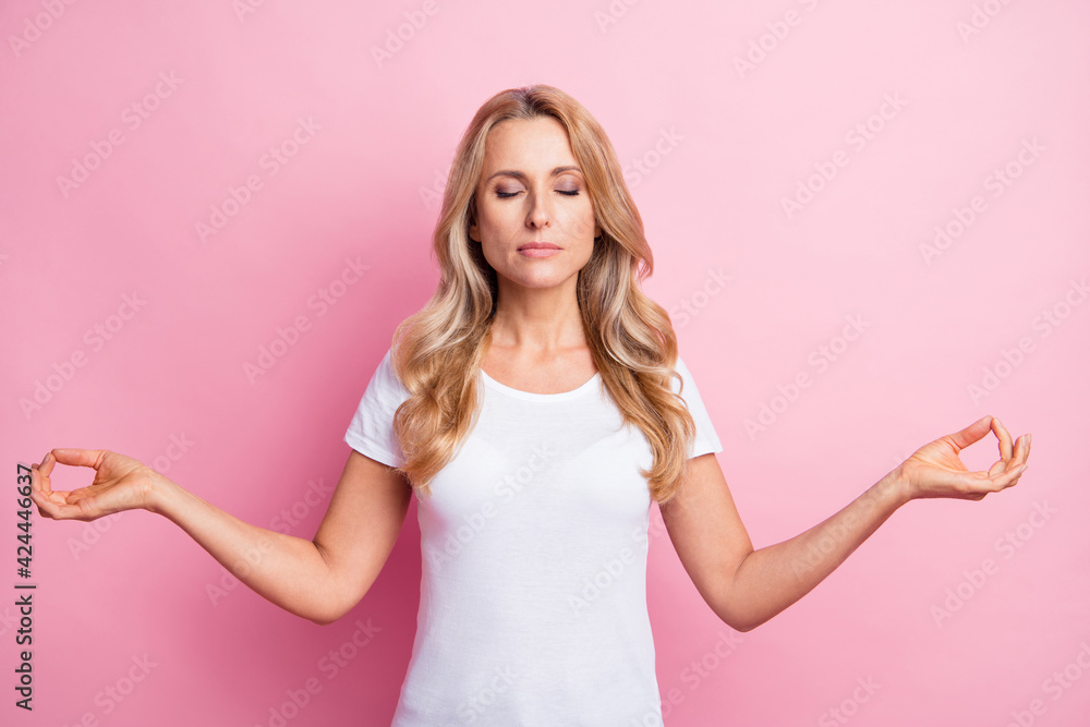 Photo of peaceful dreamy lady lotus pose meditate close eyes wear white t-shirt isolated pink color background Photo of peaceful dreamy lady lotus pose meditate close eyes wear white t-shirt isolated pink color background