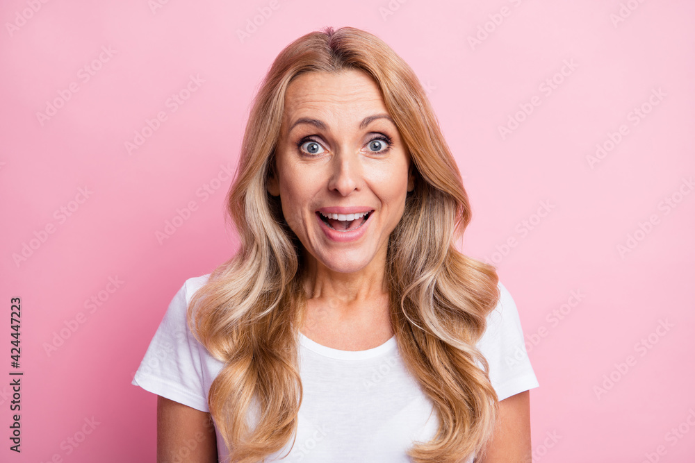 Photo of cute impressed blond lady wear white t-shirt isolated on pastel pink color background Photo of cute impressed blond lady wear white t-shirt isolated on pastel pink color background
