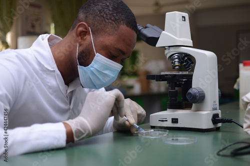 young handsome african doctor analyzing sample of an experiment in his lab
