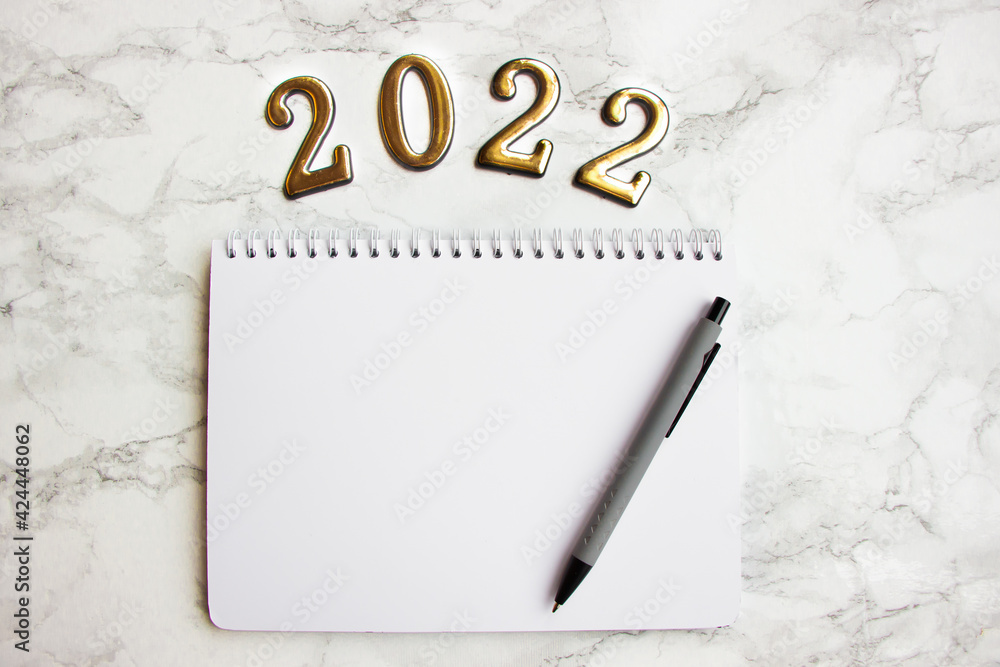 notebook with a blank sheet, a pen for writing plans for 2022 notebook with a blank sheet, a pen for writing plans for 2022