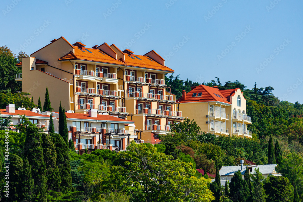 Yalta, Russia - September 30, 2019: View of coast with hotels along shore. Narrow strip of beach. Calmness and relaxation. Velvet season in Crimea. Selective focus. Yalta, Russia - September 30, 2019: View of coast with hotels along shore. Narrow strip of beach. Calmness and relaxation. Velvet season in Crimea. Selective focus.