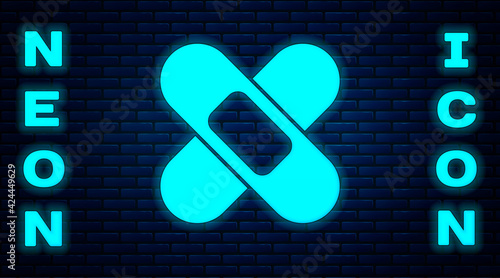 Glowing neon Crossed bandage plaster icon isolated on brick wall background. Medical plaster, adhesive bandage, flexible fabric bandage. Vector