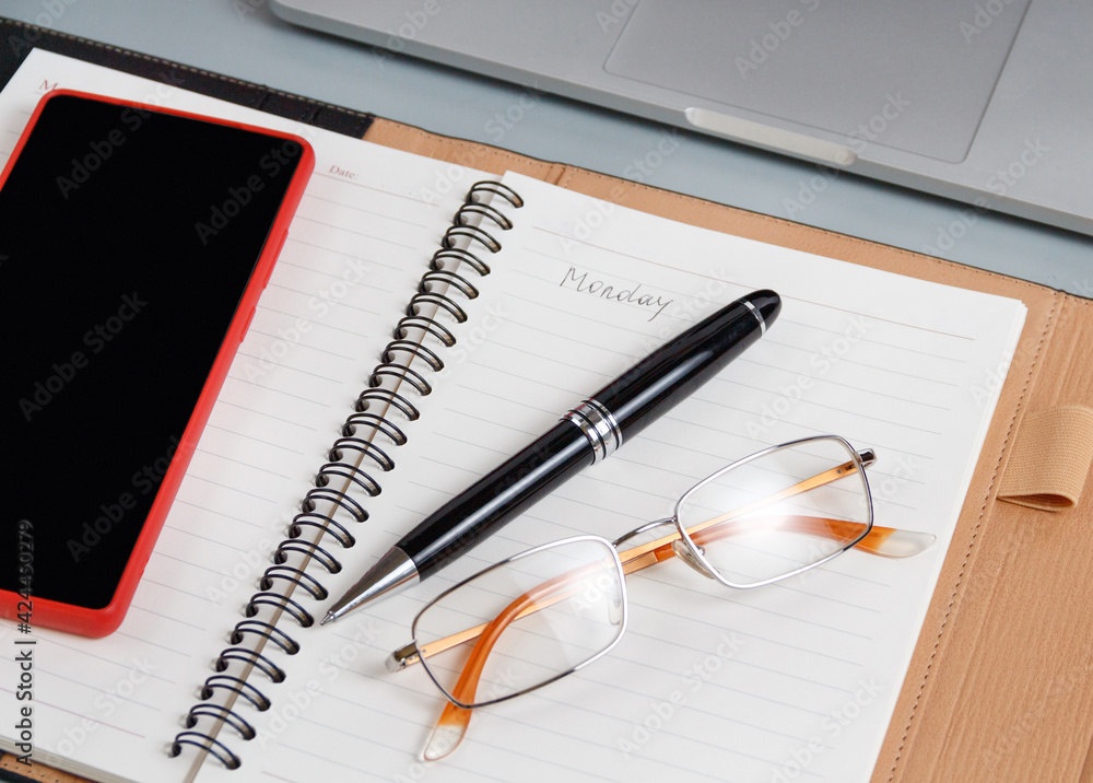 Opened agenda with handwritten MONDAY on a grey close up
