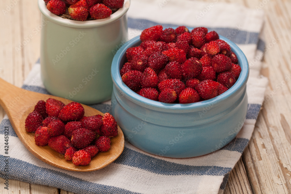 Organic berries red strawberries in ceramic bowl and wooden spoon Organic berries red strawberries in ceramic bowl and wooden spoon