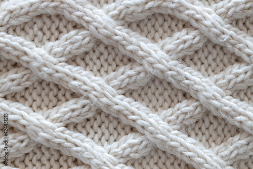 Wallpaper Mural Background from beautiful, knitted background, Aran pattern, weave from braids. Concept handicrafts, DIY, leisure, fashionable warm clothes, hobbies. Top view, macro, close-up, flat lay. Horizontal Torontodigital.ca