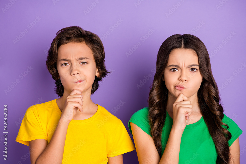 Photo of two young children sister and brother think plan serious face hold hand chin isolated on violet color background Photo of two young children sister and brother think plan serious face hold hand chin isolated on violet color background