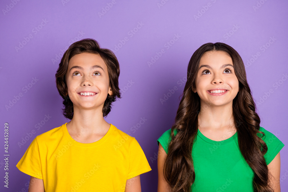 Photo of two little kid boy girl happy positive toothy smile dream look empty space isolated over violet color background Photo of two little kid boy girl happy positive toothy smile dream look empty space isolated over violet color background