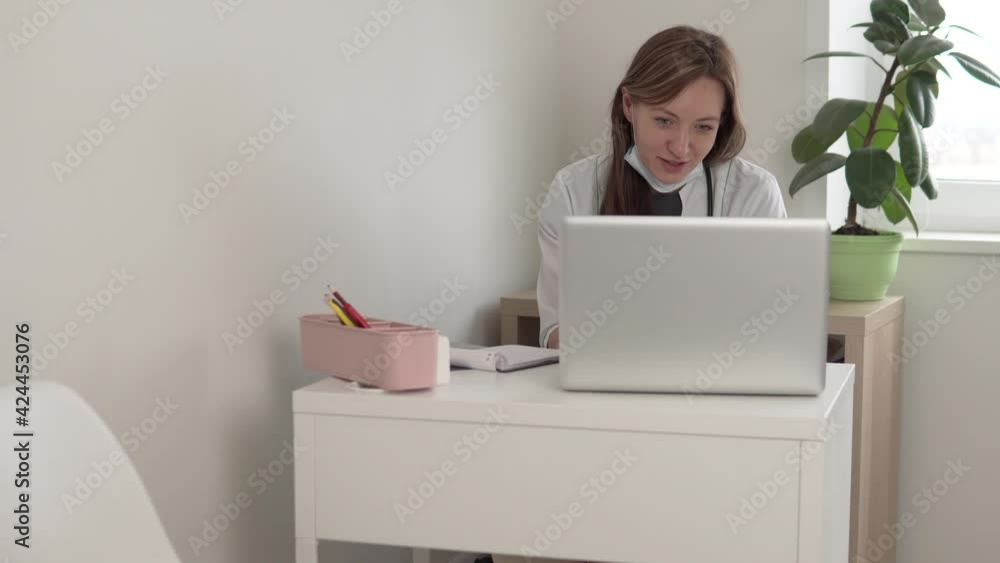 A female doctor conducts an online consultation of a patient by video communication from a computer. A female doctor conducts an online consultation of a patient by video communication from a computer.