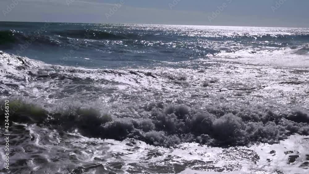 Storm and excitement at sea. Stormy waves break beautifully, forming a white foam. Sun's rays are reflected on the sea surface. Seascape. Mesmerizing beauty of nature. Weather and environment concept. Storm and excitement at sea. Stormy waves break beautifully, forming a white foam. Sun's rays are reflected on the sea surface. Seascape. Mesmerizing beauty of nature. Weather and environment concept.