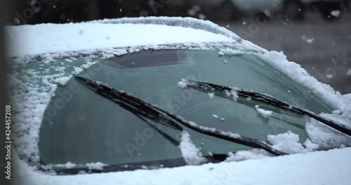 Wipers in winter remove snow from the windshield of the car. the onset of winter. flakes of snow. ice. beautiful winter. car wipers. 4K video
