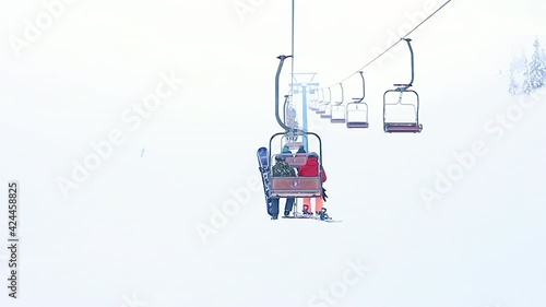 Empty ski slope with traces, supports and sun in sky at day , shooting from moving chairlift. photo