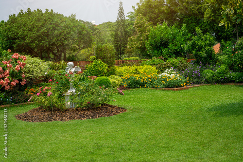 Back - front yard English cottage garden, green grass lawn, colorful flowering plant