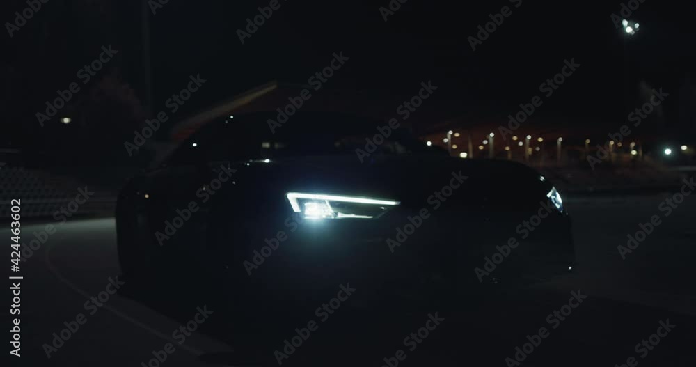Cinematic close up shot of modern racing car with switched on ...