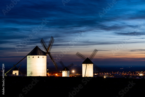 traditional whitewshed Spanish windmills in La Mancha just after sunset under a cool blue night sky