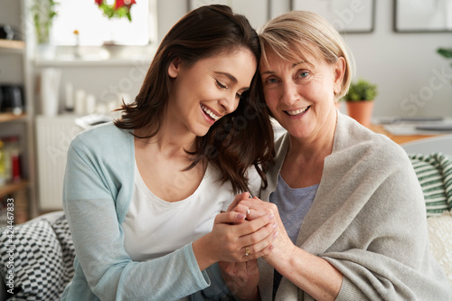 Foto Mother and adult daughter holding hands together at home