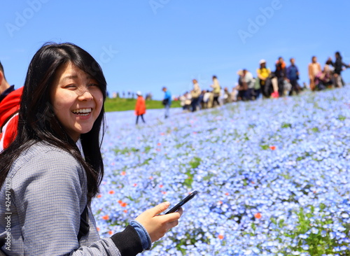 茨城県の観光地　青いネモフィラが有名なひたち海浜公園で遊ぶ女性 photo