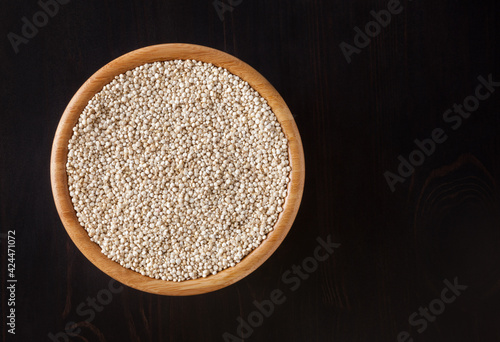 Obraz na płótnie Dried white quinoa seeds in wooden bowl on black wooden background w salonie