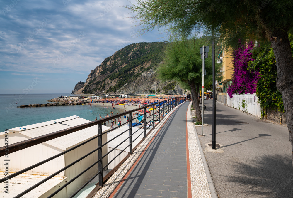 Obraz premium Monterosso, Liguria, Italy. June 2020. The promenade offers a pleasant view of the beaches with the bathing establishments and the surrounding nature. Beautiful summer day