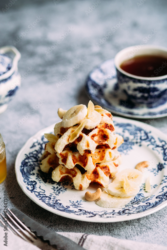Belgian waffles with banana and honey on a vintage blue plate