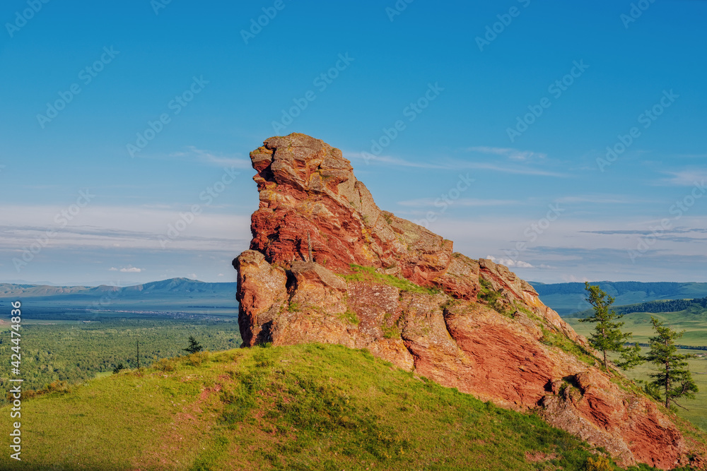 Red rock among the hills and steppes of Khakassia Grandfather in Kazanovka Ded sunset