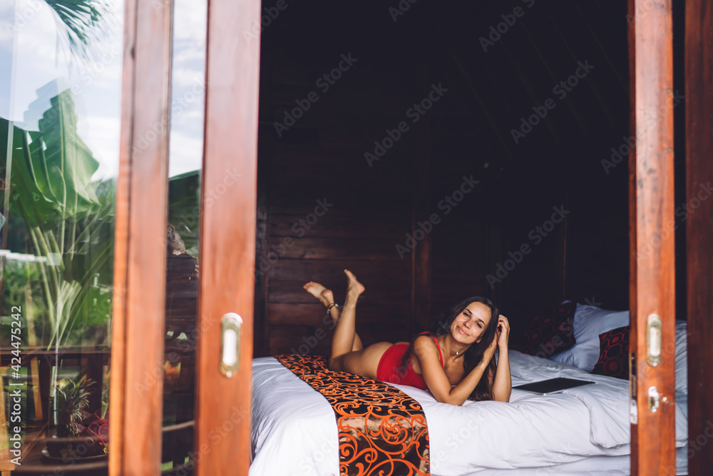 Obraz premium Serene woman lounging on bed in hotel room