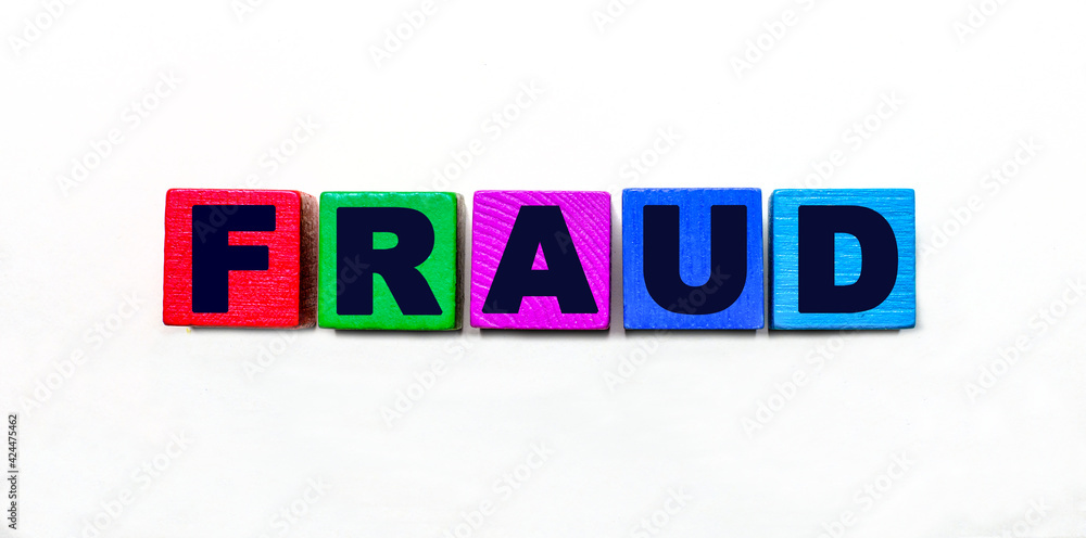 Fototapeta premium The word FRAUD is written on colorful cubes on a light background
