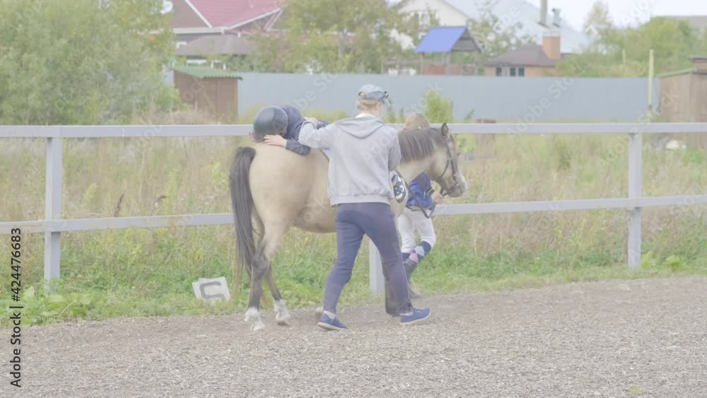 Hippotherapy for young children is the prevention many serious diseases. Concept of spring and summer sports, care, good mood, horse trainings; equistrain club; hippotherapy; vacation and hobby Hippotherapy for young children is the prevention many serious diseases. Concept of spring and summer sports, care, good mood, horse trainings; equistrain club; hippotherapy; vacation and hobby