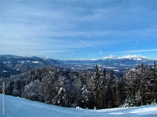 Scenic winter view of Gorenjska, Slovenia with Jelovica plateau and Karawanks mountain range and a forest