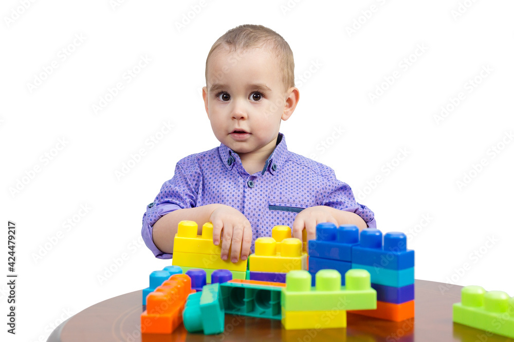 Kid playing with colored cubes on the table, isolated. Kid playing with colored cubes on the table, isolated.