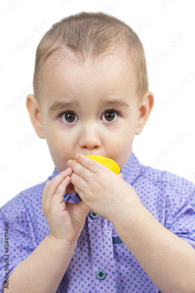 Little boy bites juicy sour lemon white background. Little boy bites juicy sour lemon white background.