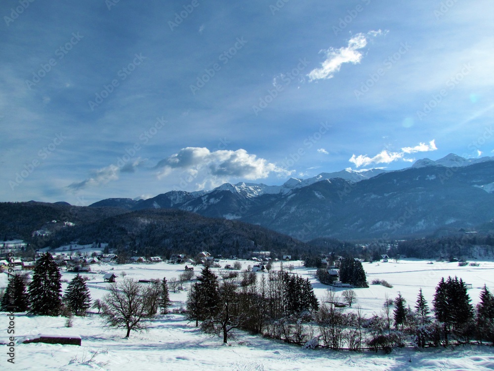 View of rural landscape near Bohinj in Gorenjska, Slovenai and mountains in Julian alps behind and the village of Stara Fuzina