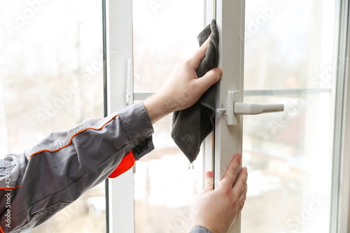 window repair service concept. lubrication of sealing rubber bands of plastic window