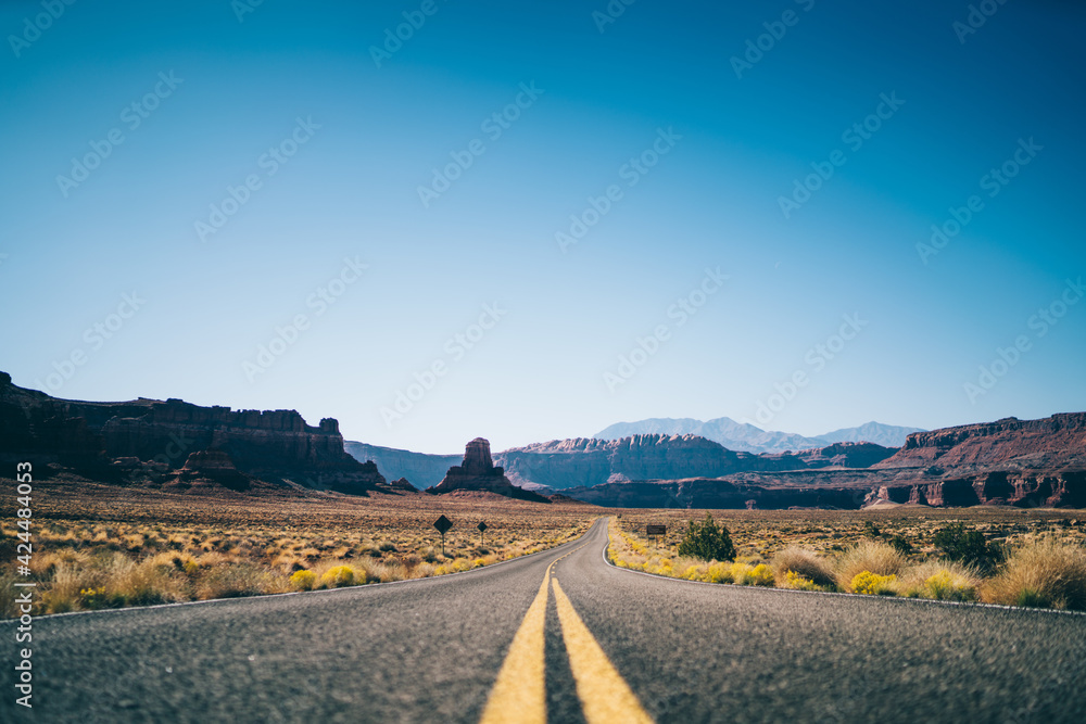 Long empty asphalt road with double solid in dry valley in USA