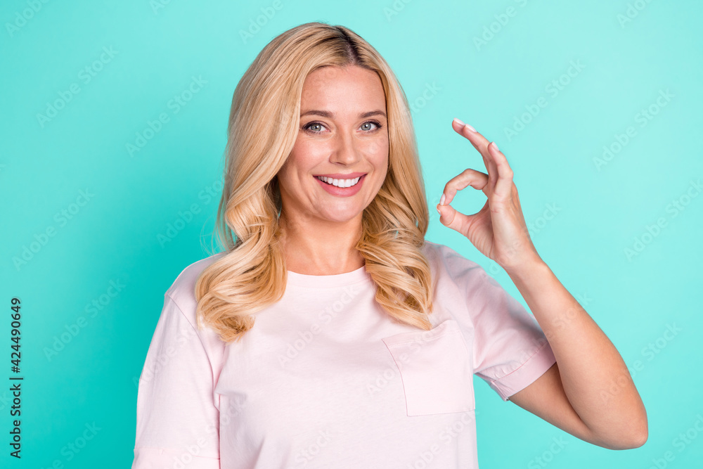 Fototapeta premium Portrait of attractive cheerful wavy-haired woman showing ok-sign agree isolated on bright green turquoise color background